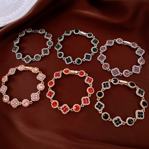 Détail de bracelets trèfle de luxe avec cristaux colorés sur tissu en soie sombre