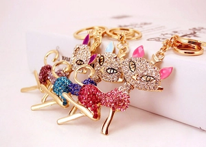 Detailed row of golden metal fox keychains with purple, blue, red and pink rhinestones