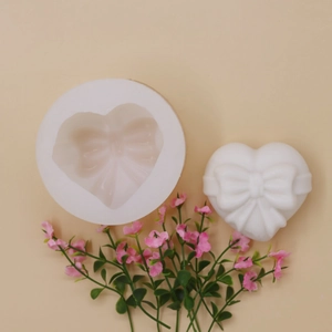 Silicone heart bow mold for DIY baking and mousse cakes on a warm beige background