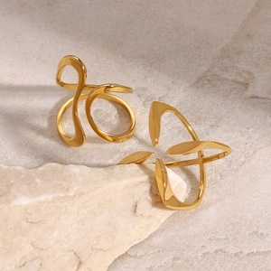 Minimalist 18K gold stainless steel rings with irregular fluid curves on stone display
