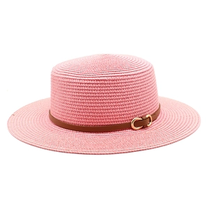 Vue détaillée d'un chapeau de paille rose avec ruban en cuir brun et boucle dorée