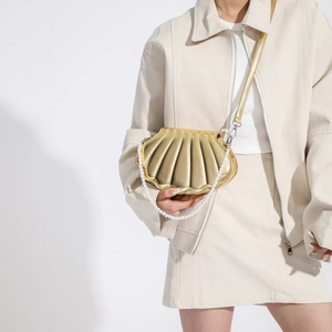 Champagne shell-shaped crossbody bag with pearl handle and metallic pleats