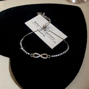 Detail of adjustable silver infinity bracelet with pavé white cubic zirconia accents