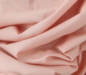 Close-up of high-quality pink combed cotton fabric with smooth texture and soft folds