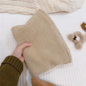 Macro detail of soft beige sherpa fleece texture on a warm winter handheld clutch bag