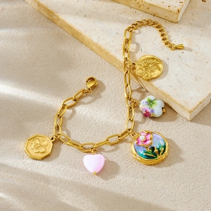 Vintage gold-plated charm bracelet featuring colorful enamel flowers and butterfly pendant