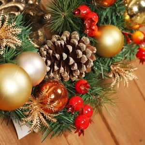 Christmas wreath with golden balls, pine cones, and reindeer head on wood background