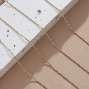 Close-up of golden snake chain necklace showcasing flexible metallic scale texture