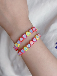 Close-up of colorful heart-shaped enamel elastic bracelets with iridescent stones