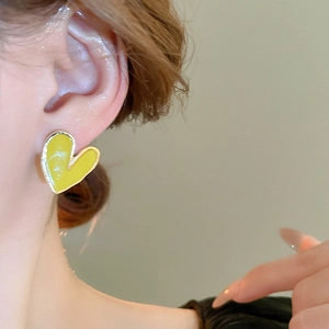 Vue détaillée d'un mannequin portant des boucles d'oreilles cœur en émail jaune vif