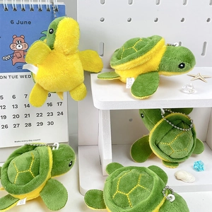 Detail view of cute plush turtle keychain with vibrant yellow and green soft fabric
