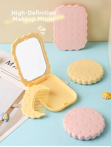 Close-up of biscuit-shaped folding makeup mirror and matching comb in pink and yellow
