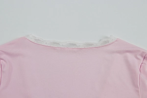Close-up of pink V-neck top showing delicate white lace trim and smooth fabric texture