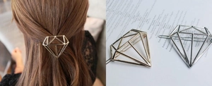 Detail of geometric diamond-shaped metal hair clips in gold and silver finishes