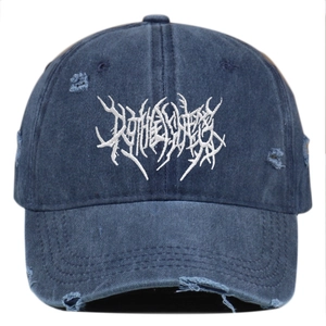 Distressed dark blue washed cotton baseball cap with white gothic embroidery and torn effect