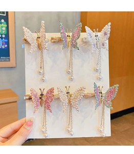 Detail of colorful butterfly hair clips with golden tassels and pearl beads for girls