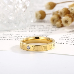 Close-up of golden Roman numeral ring with diamonds on a creative studio background