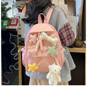 Pink Korean-style backpack for students with plush star charms and a bear pendant detail