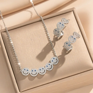 Silver smile face jewelry set with blue zircon eyes in a beige display box