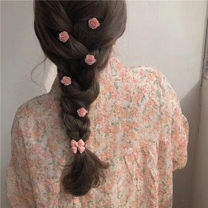 Pink ribbon bow hair tie and rose hair clips set shown on elegant braided hairstyle