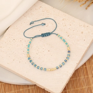 Detail of blue crystal beads and golden spacers on a hand-woven adjustable bracelet