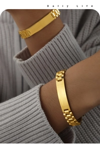 Close-up of gold watch-band style chain bracelet with engravable plaque on a knit sleeve