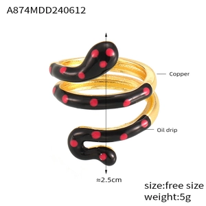 Detail of snake shaped gold plated copper ring with red dotted black oil drip finish