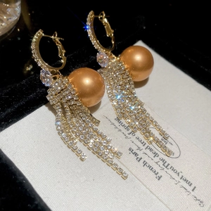 Macro detail of French vintage tassel earrings with pearls and pavé cubic zirconia