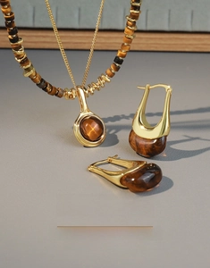 Detailed set of retro tiger eye beaded necklace and U-shaped earrings with gold metal finish