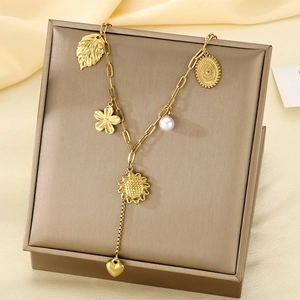 Gold stainless steel necklace with heart sunflower and pearl charms on a display box