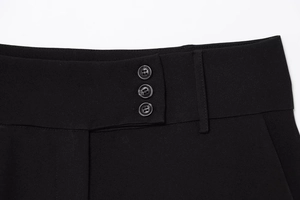 Details einer schwarzen Twill-Hose mit Dreifach-Knopfverschluss und Gürtelschlaufen