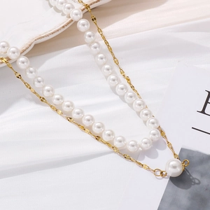 Detail of elegant double-layer necklace with white faux pearls and gold titanium steel chain