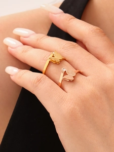 Close-up of two adjustable 18k gold butterfly rings with small diamond accents on fingers