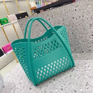 Detail of the teal hollowed-out grid structure and reinforced base of the tote bag