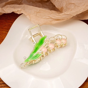 Detail of lily of the valley hair claw clip with pink resin flowers and green leaves