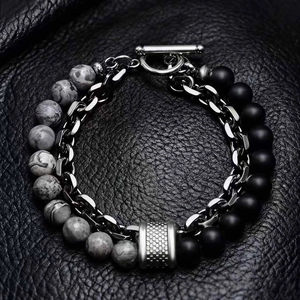Double-layered beaded bracelet with map stone and metal chain on black leather background