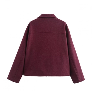 Détail macro du tissu du manteau en laine bordeaux et finitions des coutures au dos