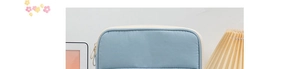 Detail of light blue quilted laptop sleeve with dual zippers and soft texture