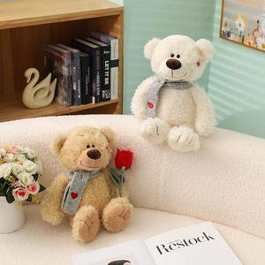 Lindos osos de peluche con bufandas de corazón y rosa de ganchillo en un sofá suave