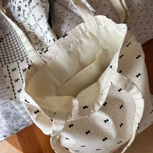 Internal view of canvas tote bag with black polka dots, bow patterns and inner pocket