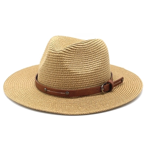 Detailed close-up of woven straw fedora hat with brown leather belt buckle detail