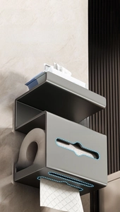 Wall-mounted dark grey tissue holder with top shelf and multi-directional paper outlet