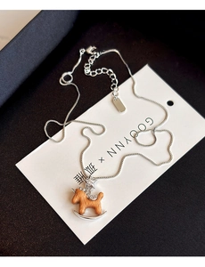 Détail du pendentif cheval à bascule en bois avec étoiles en zircon et chaîne boîte