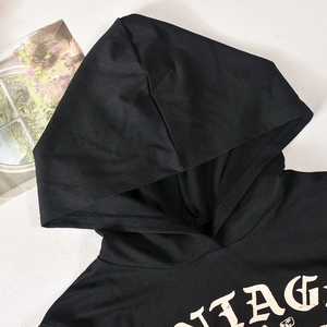 Detailed close-up of a black cropped hoodie featuring vintage letter print on soft fabric