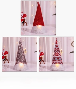 Detailed view of three glowing Christmas gnomes with sequined hats and LED light base