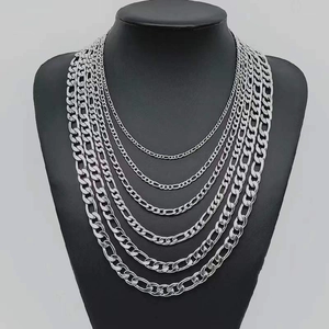 Multiple silver Figaro chain necklaces in various widths on black mannequin display