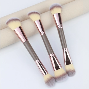 Detailed macro view of 3 dual-ended makeup brushes with rose gold ferrules and soft bristles