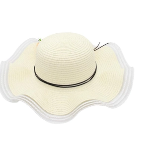 Détail d'un chapeau de soleil tressé avec bord ondulé élégant et ruban noir décoratif