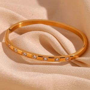 Detail of 18K gold-plated stainless steel bangle with inlaid circular cubic zirconia