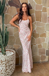 Detail of floral spaghetti strap maxi dress featuring pink blossom pattern on white fabric